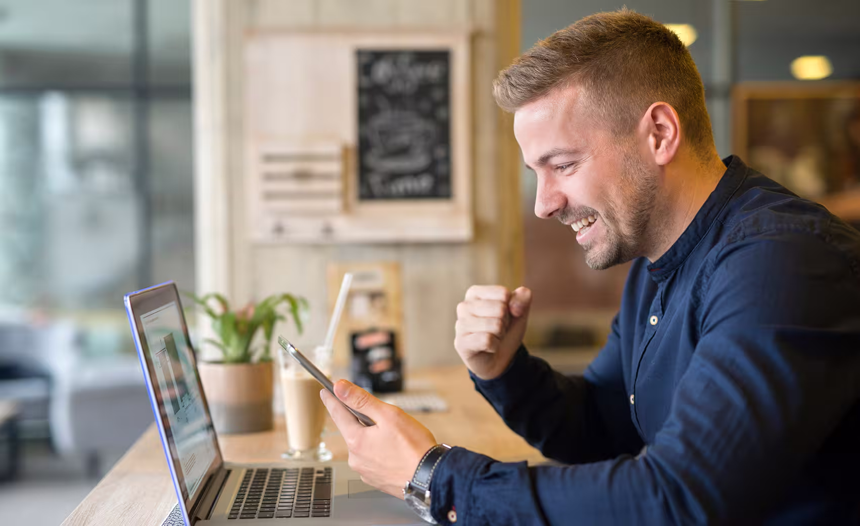 A man staring at a mobile screen excited
